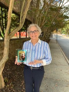 Anne McDonnell standing outside holding her award plaque