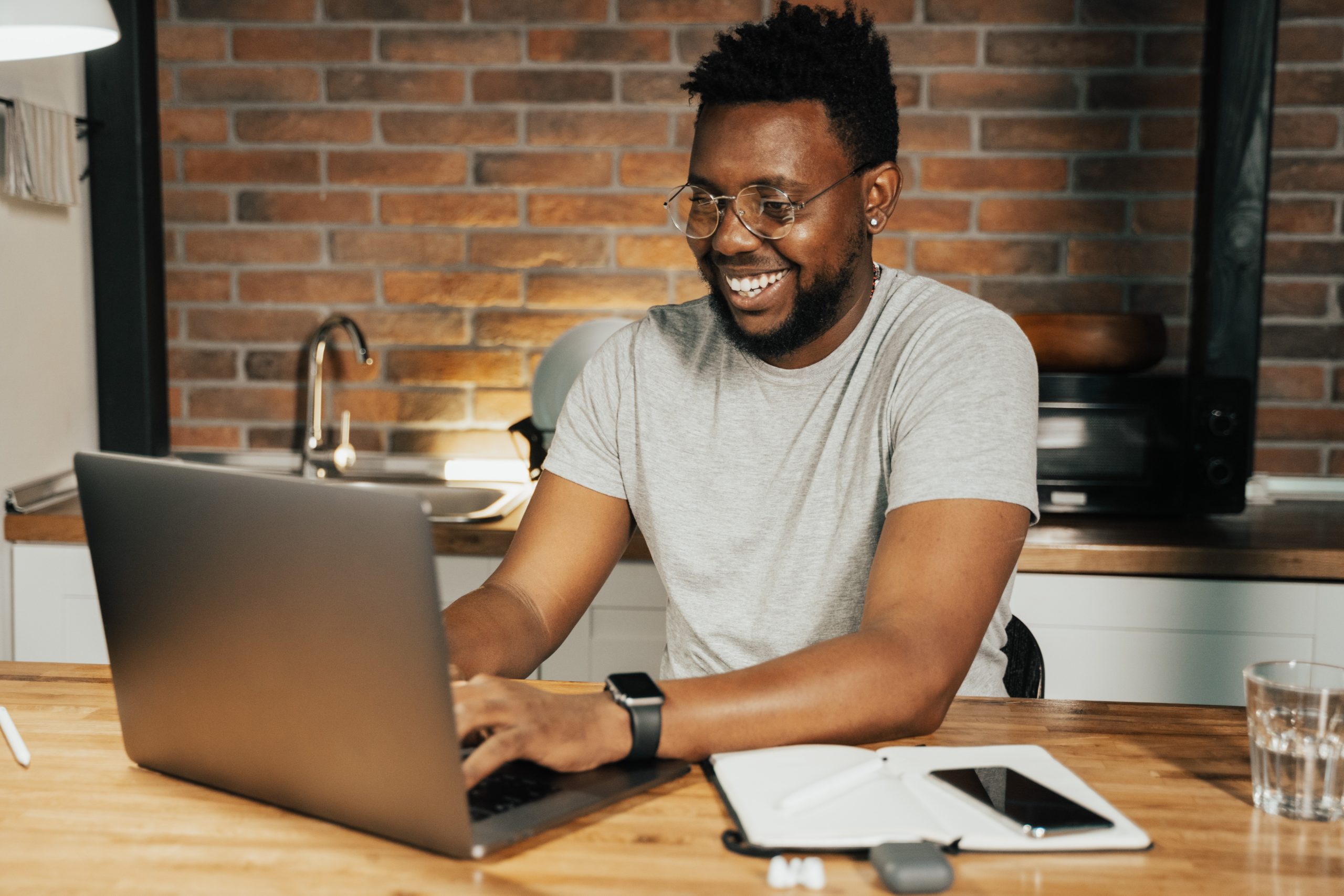 Man smiling, using a computer
